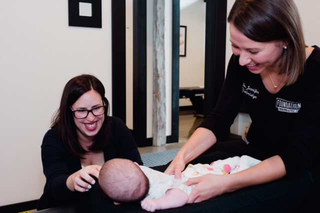 Chiropractor performing gentle adjustment on a baby to support infant health